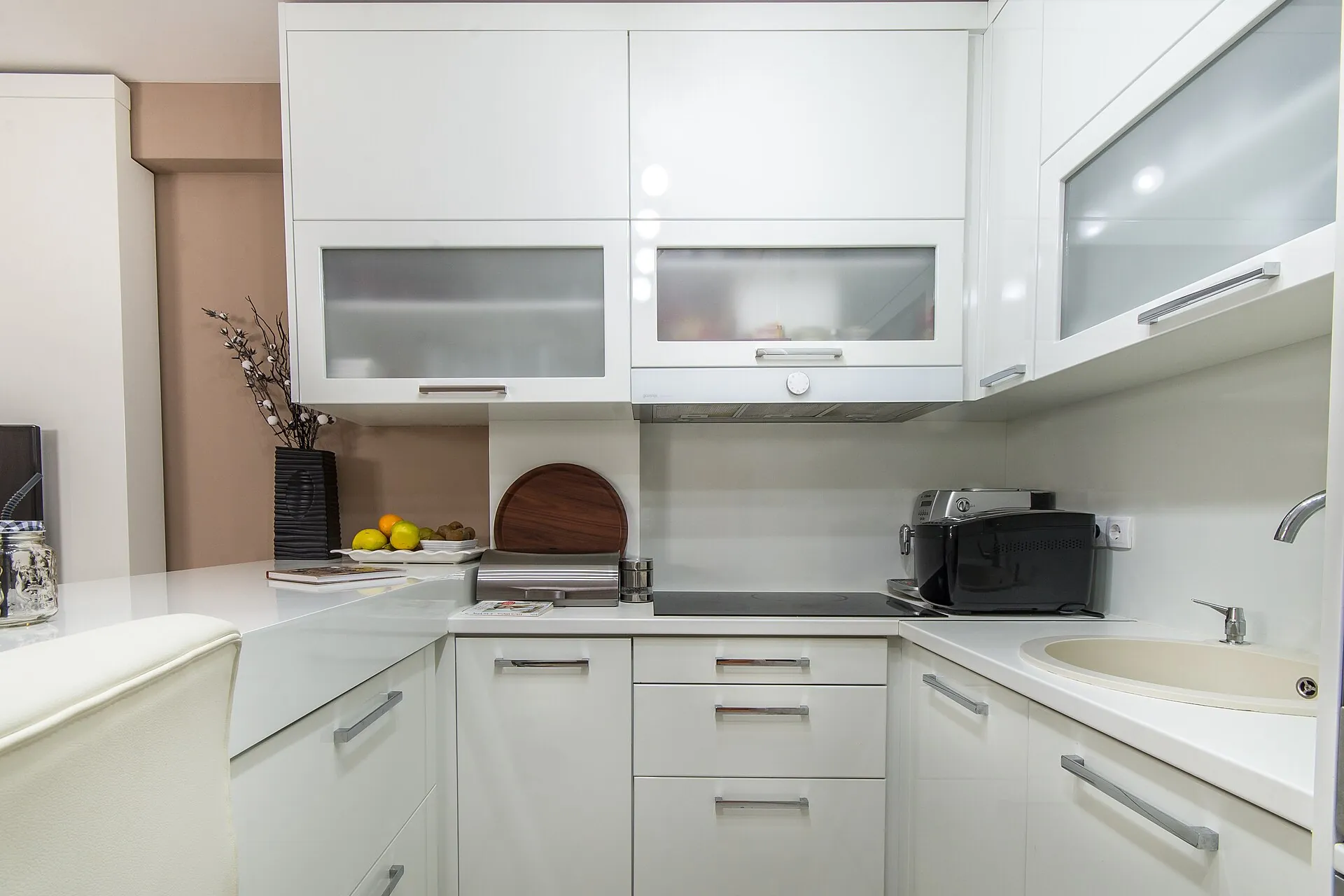 Bright white kitchen with clear, freshly wiped counters and a clean sink